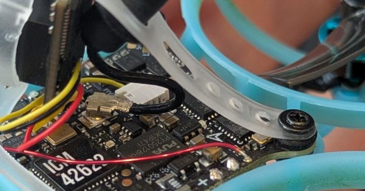 Macro photo of the Air75 II flight controller inside its frame, wires and gyro chip visible
